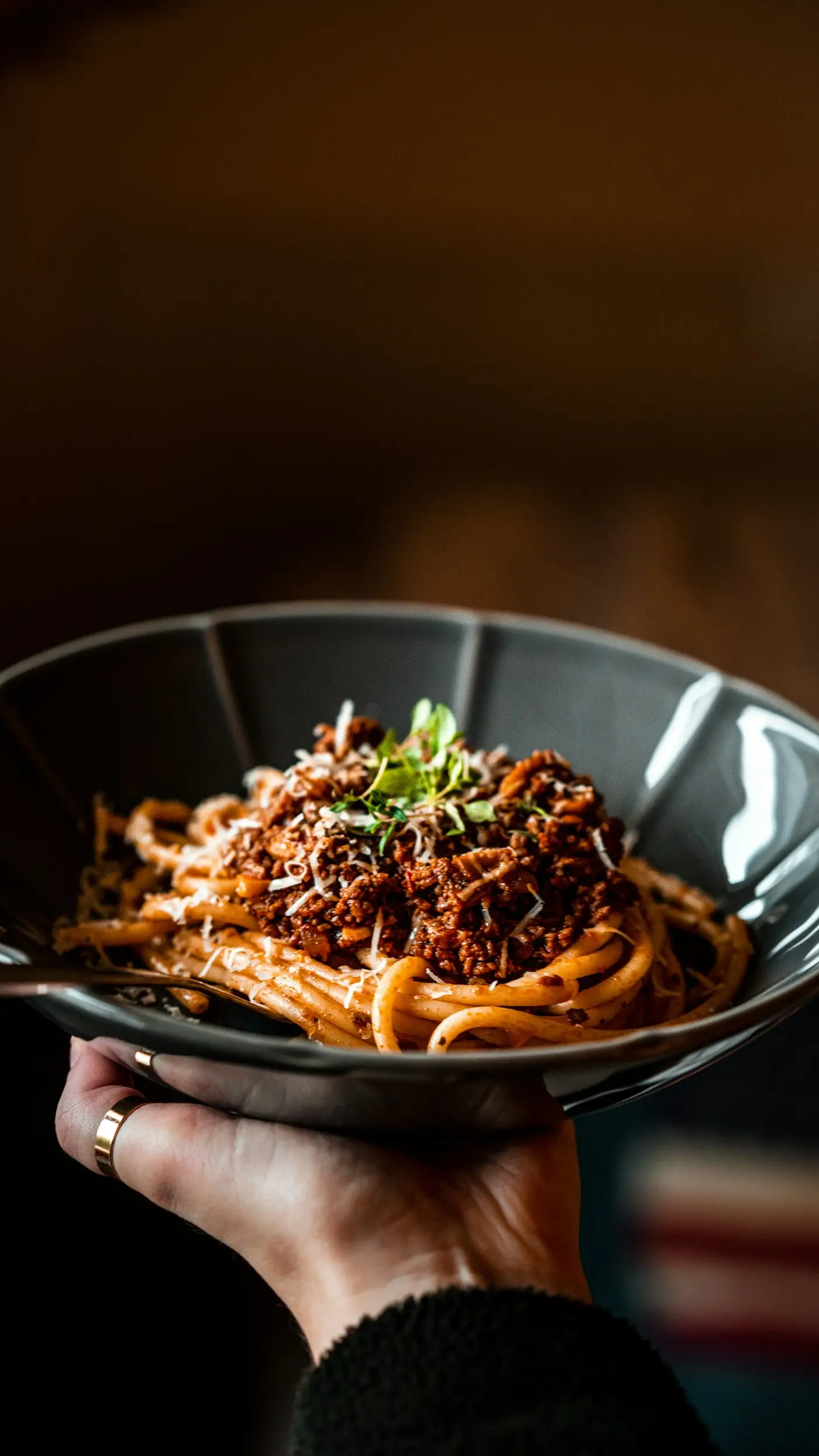 Assiette de spaghetti tenue à la main